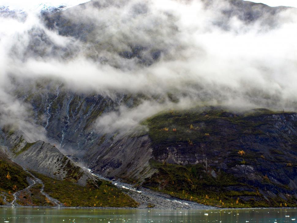 Free Image of Fog draped mountain by a glacial lake 
