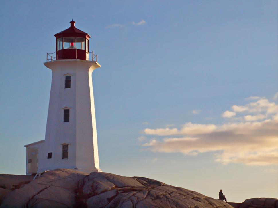 Free Image of Lighthouse on rocky shore during sunset 