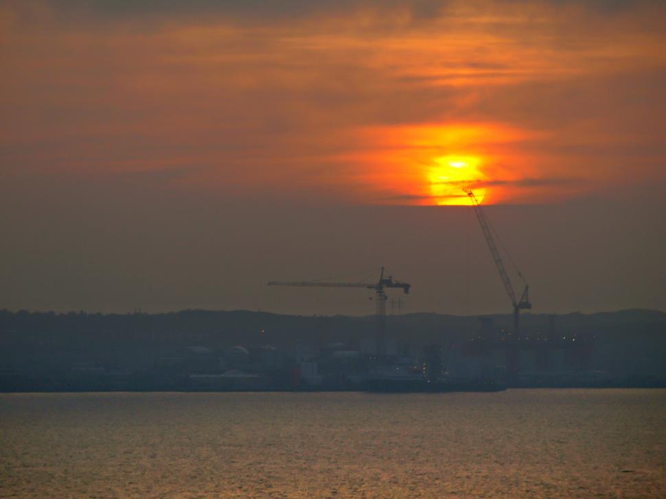 Free Image of Sunset over industrial harbor with cranes 