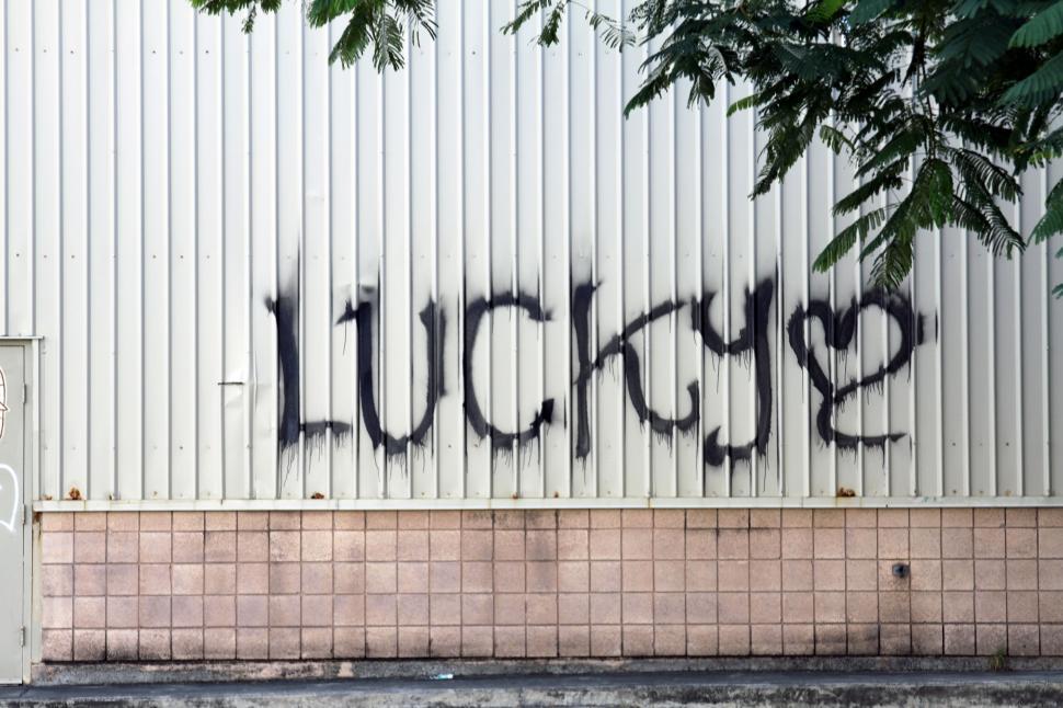 Free Image of Graffiti tag spelling lucky on urban wall 