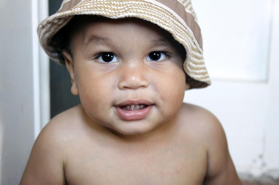 Free Image of Toddler in a hat with a joyful expression 