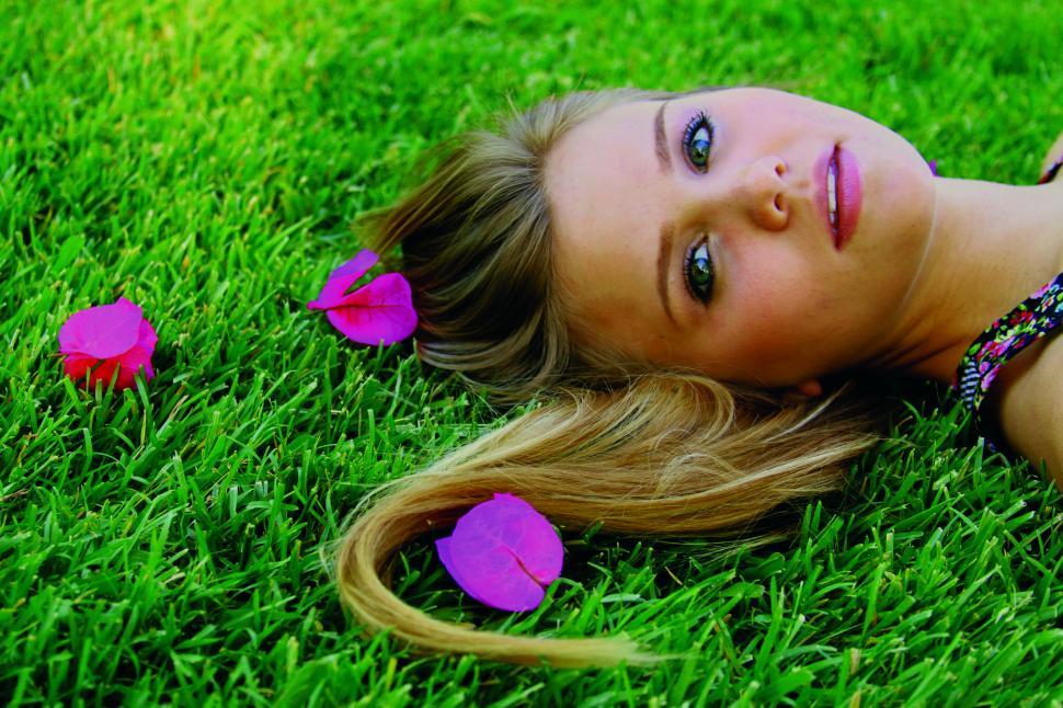 Free Image of Young girl s hair on grass with pink petals 