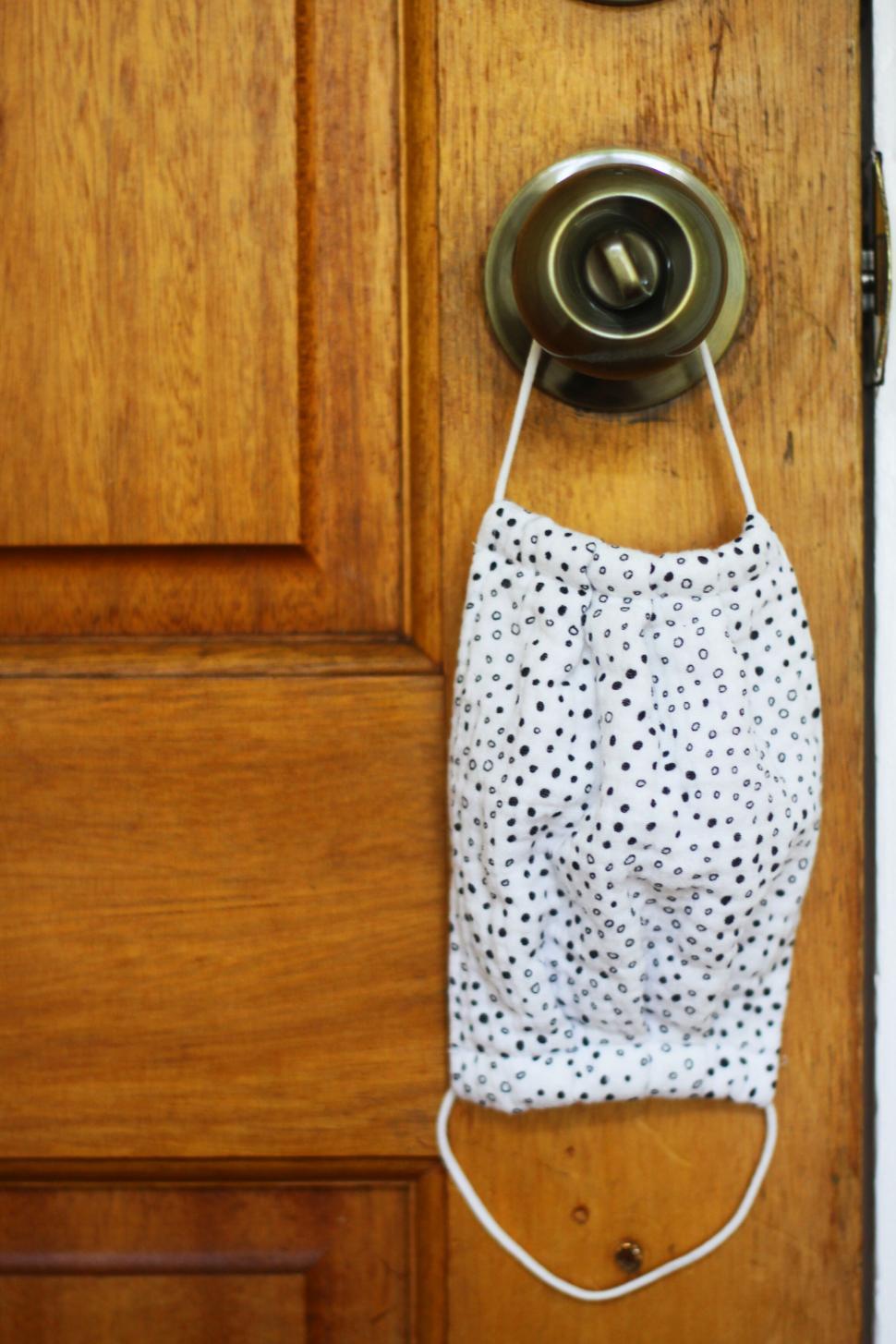 Free Image of Face mask hanging on a door knob 