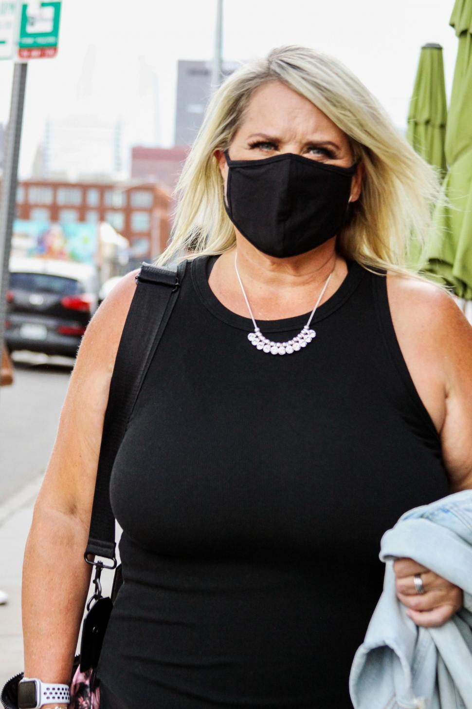 Free Image of Woman wearing a black tank top in the city 