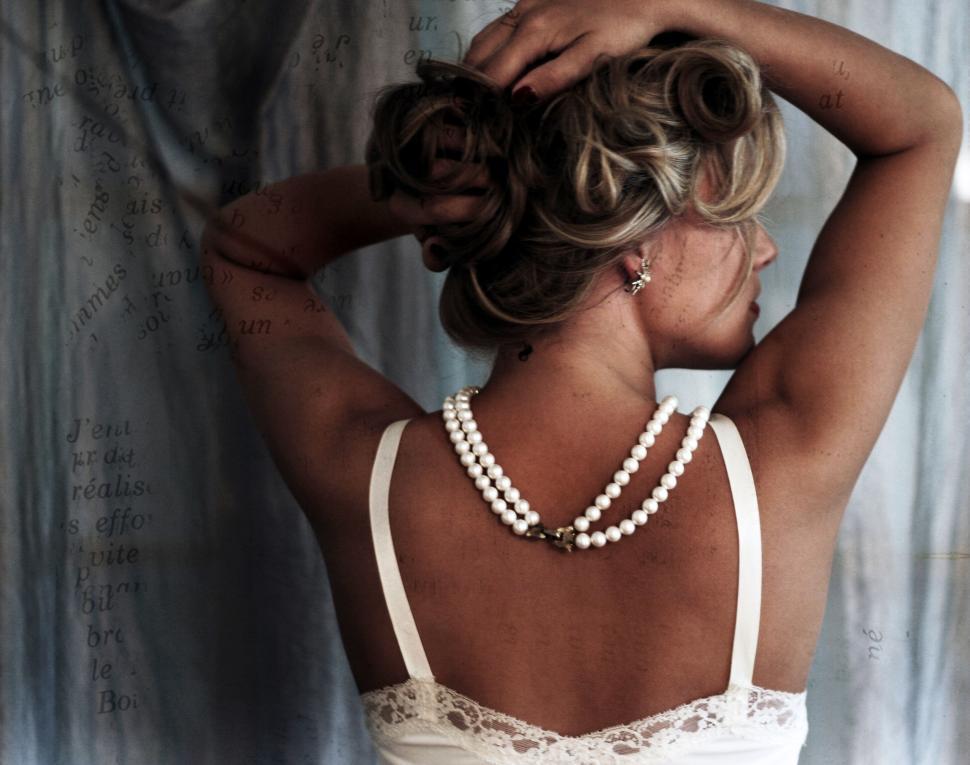 Free Image of Elegant lady with pearls and blurred face 