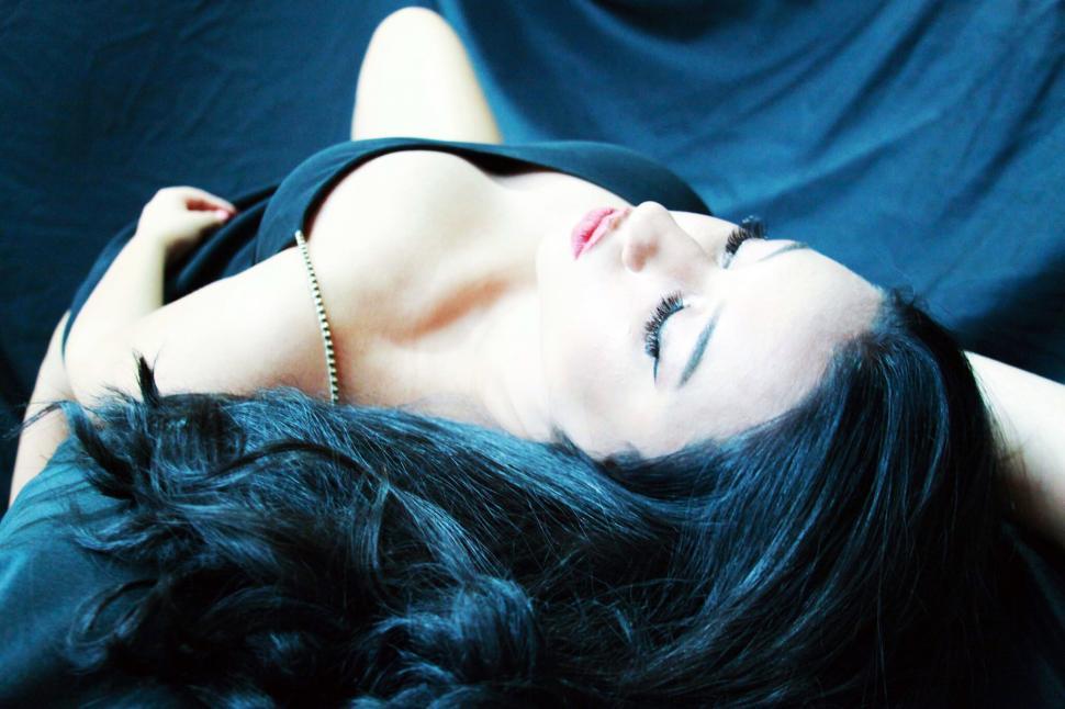Free Image of Woman lying with black feathers 