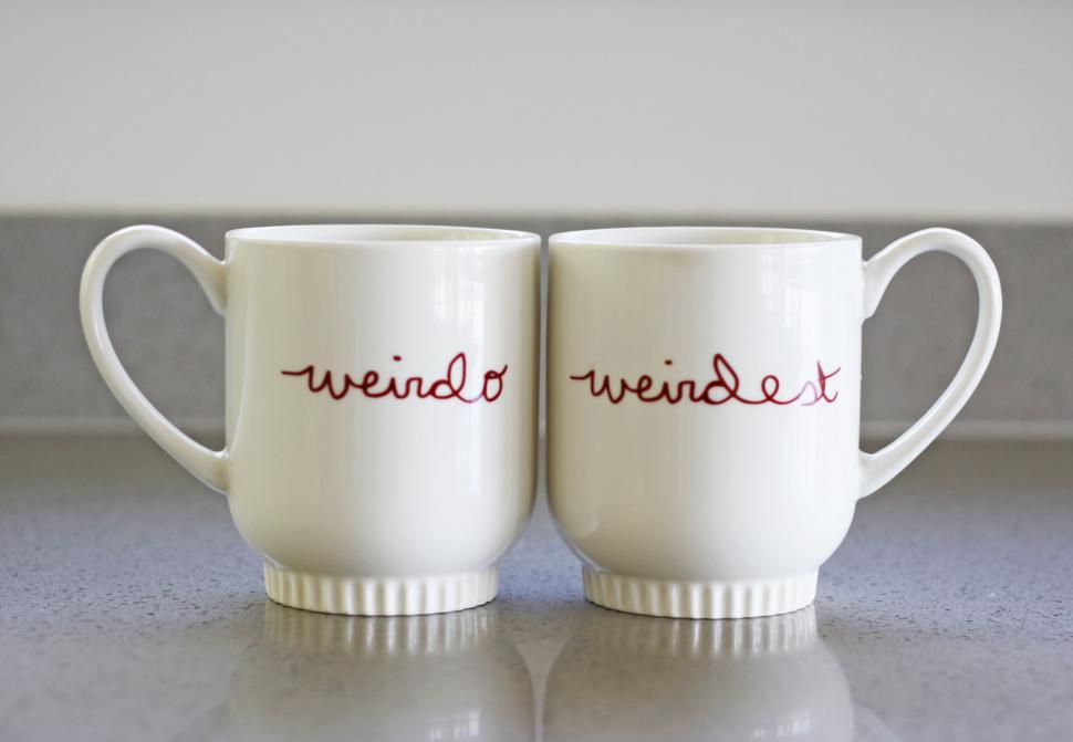 Free Image of Two white mugs with weirdo and weirdest text 