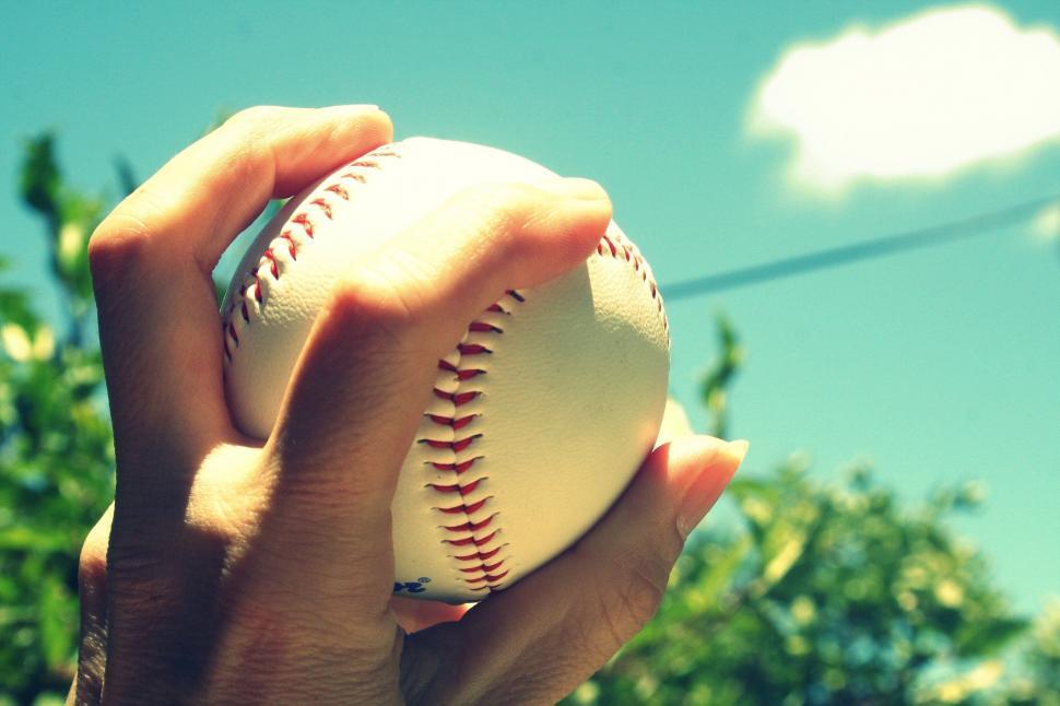 Free Image of Hand holding baseball against sky 