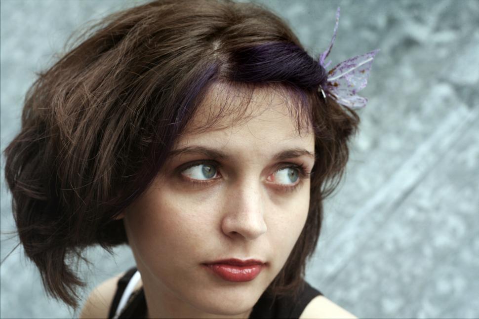 Free Image of Woman with purple hair accessory looking away 