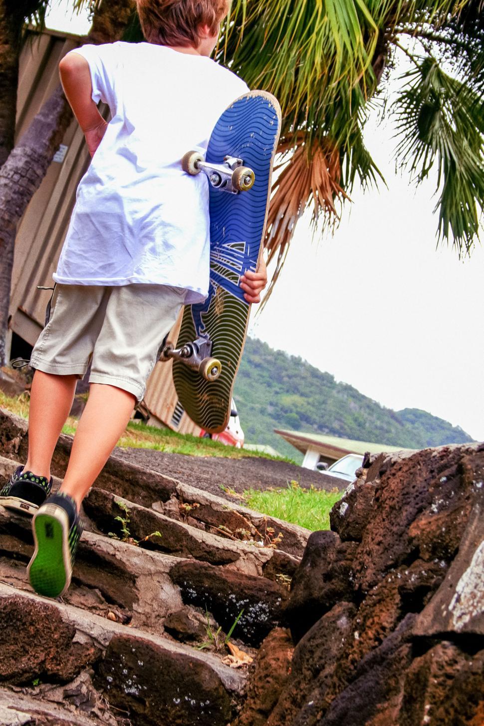Free Image of Boy With Skateboard Climbing Up Rustic Steps 