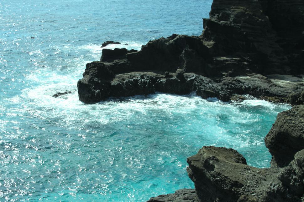 Free Image of Vivid blue ocean water against rocky cliff 