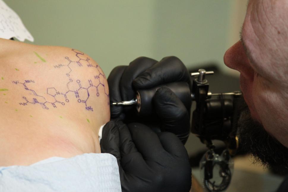 Free Image of Tattoo Artist at Work on a Chemistry Design 