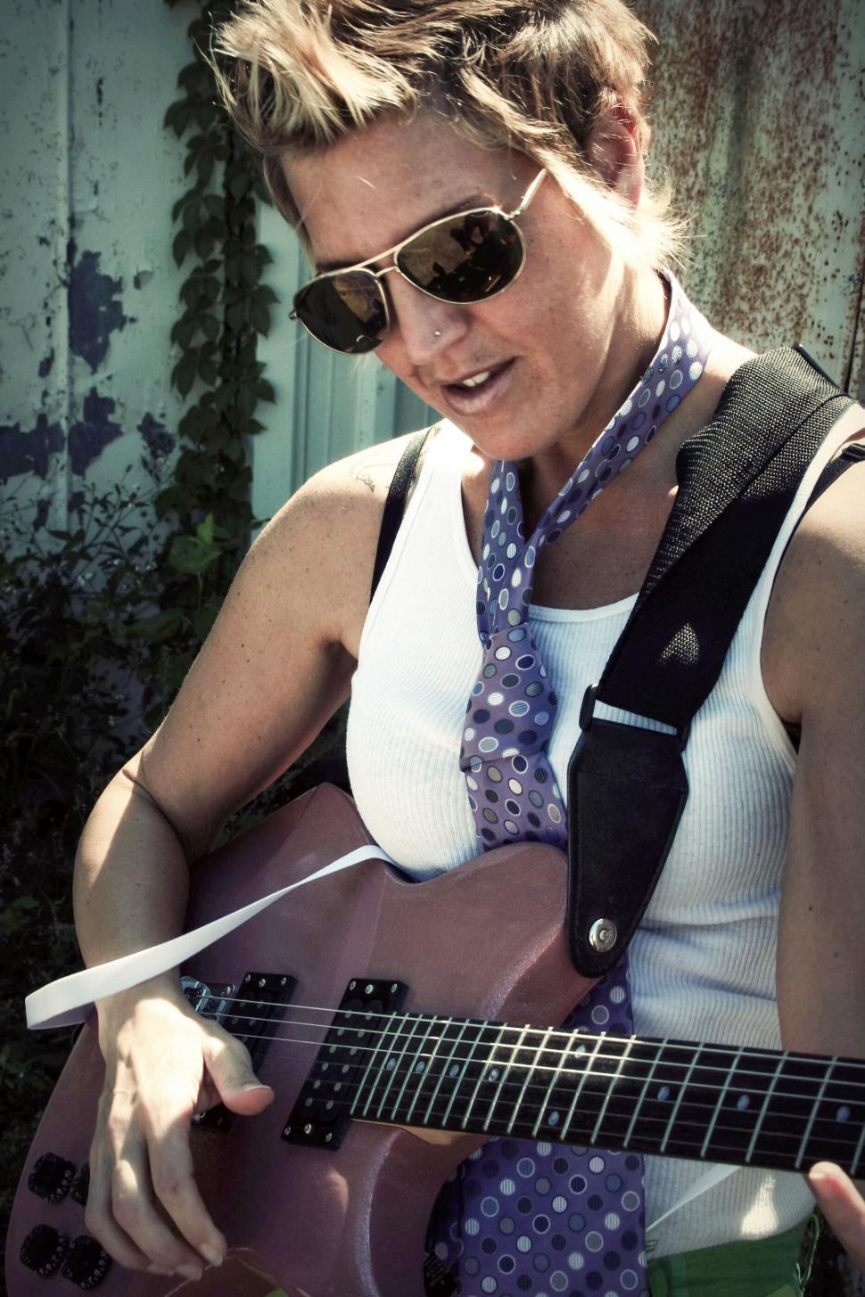 Free Image of Woman playing guitar outdoors 