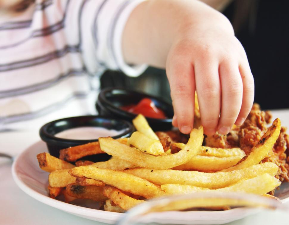 Free Image of Child reaching for french fries on plate 