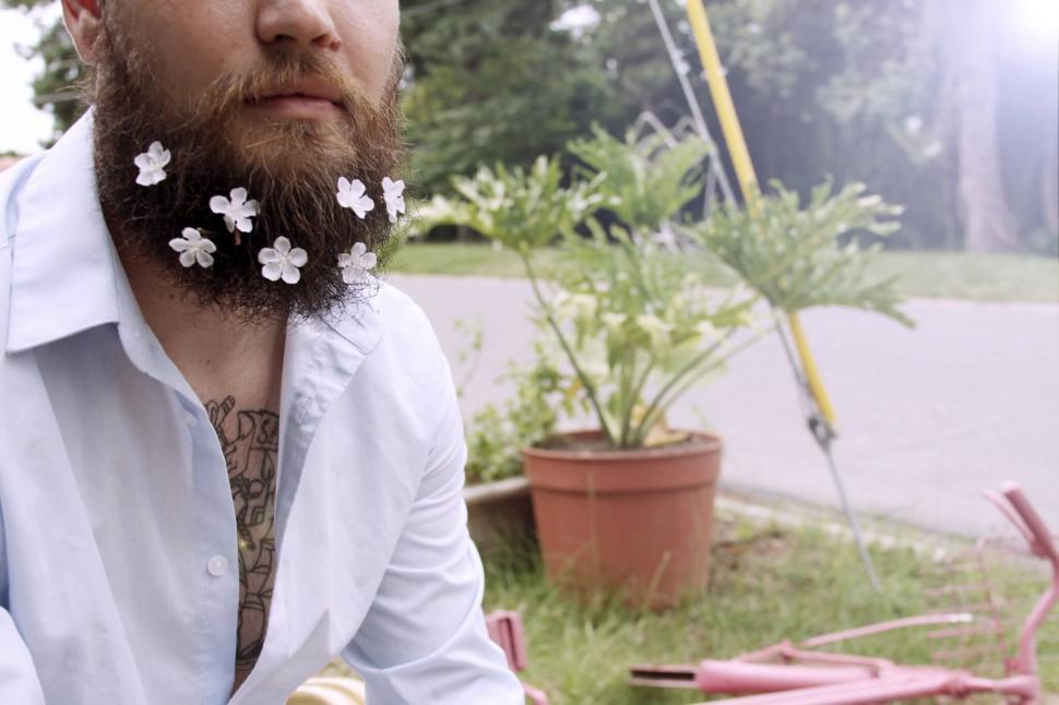 Free Image of Man with tattoos and daisy flowers 