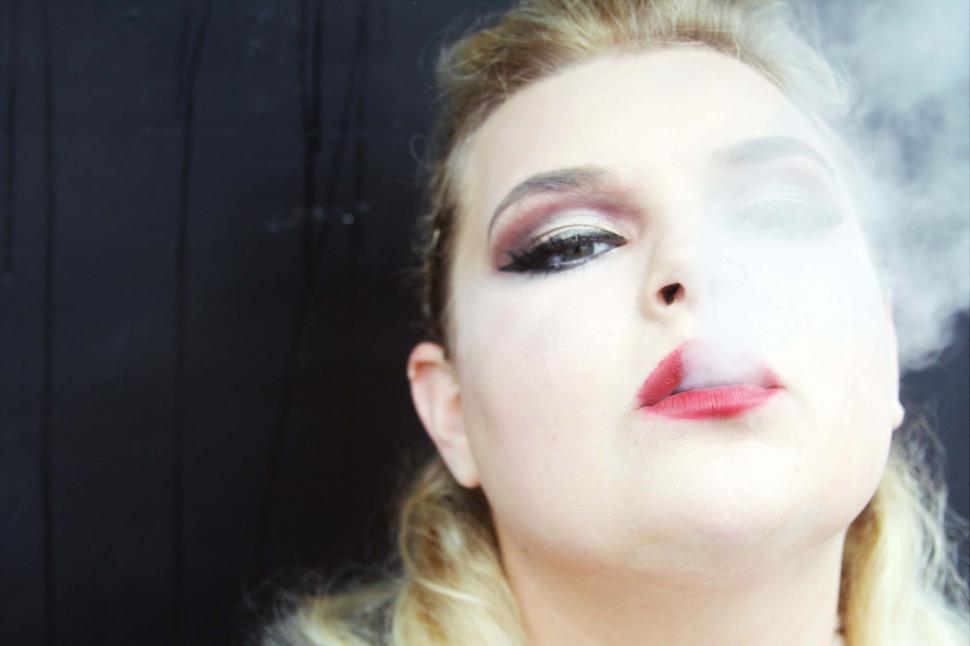 Free Image of Woman exhaling smoke dramatically 