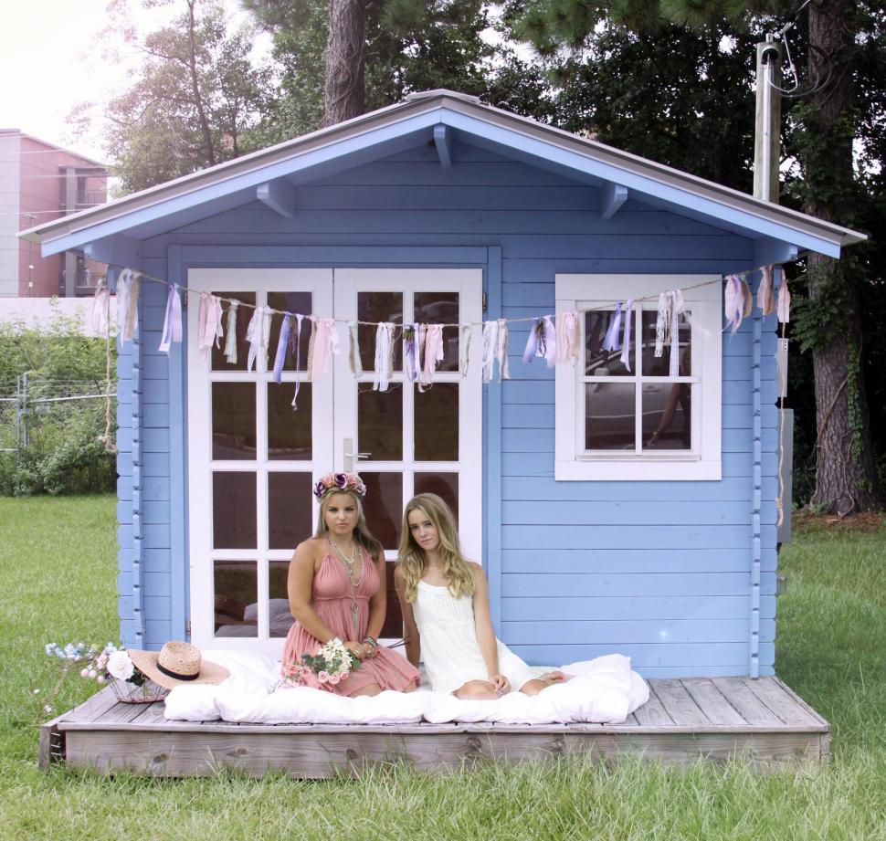 Free Image of Two women on porch of a small blue house 
