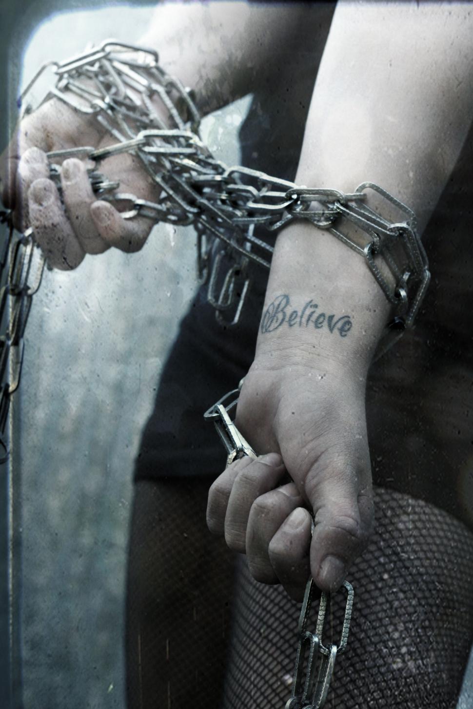 Free Image of Hands chained with tattoo saying Believe 