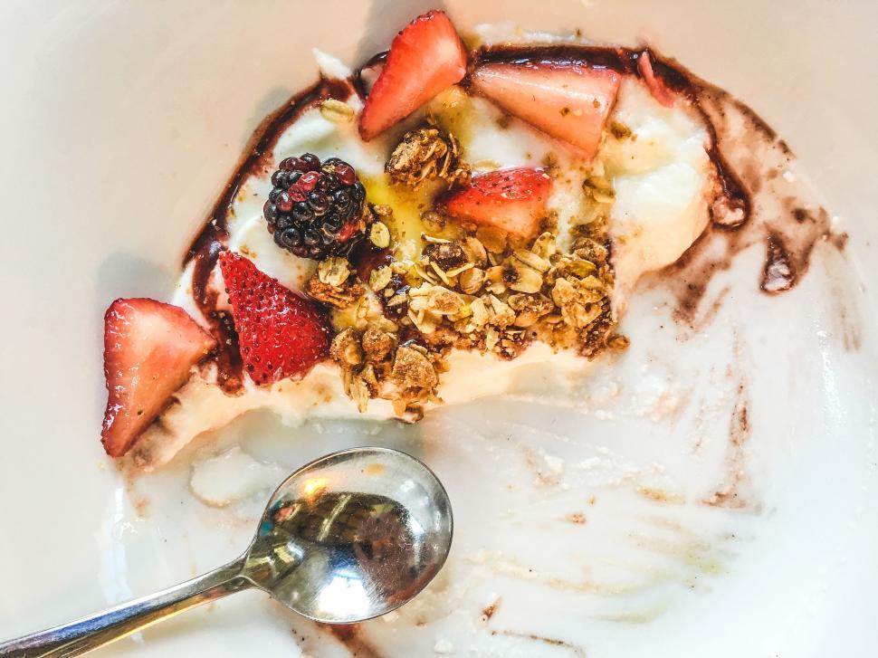 Free Image of Half-eaten yogurt with fruits and granola 