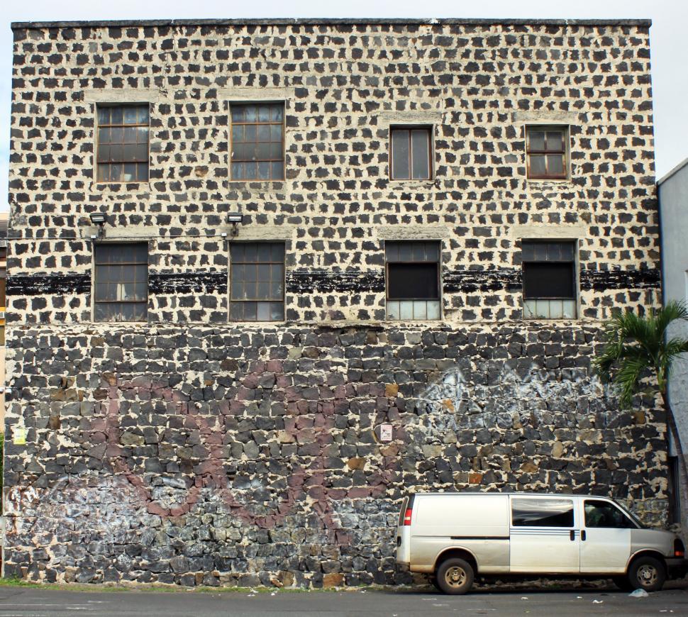 Free Image of Old stone building with a van in front 