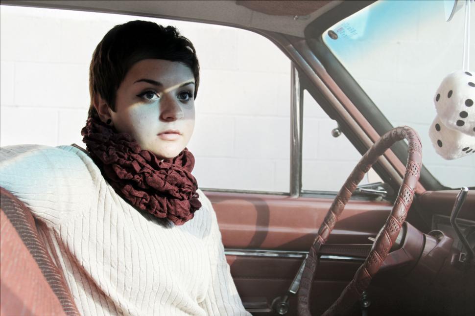 Free Image of Woman sitting in vintage car looking out 