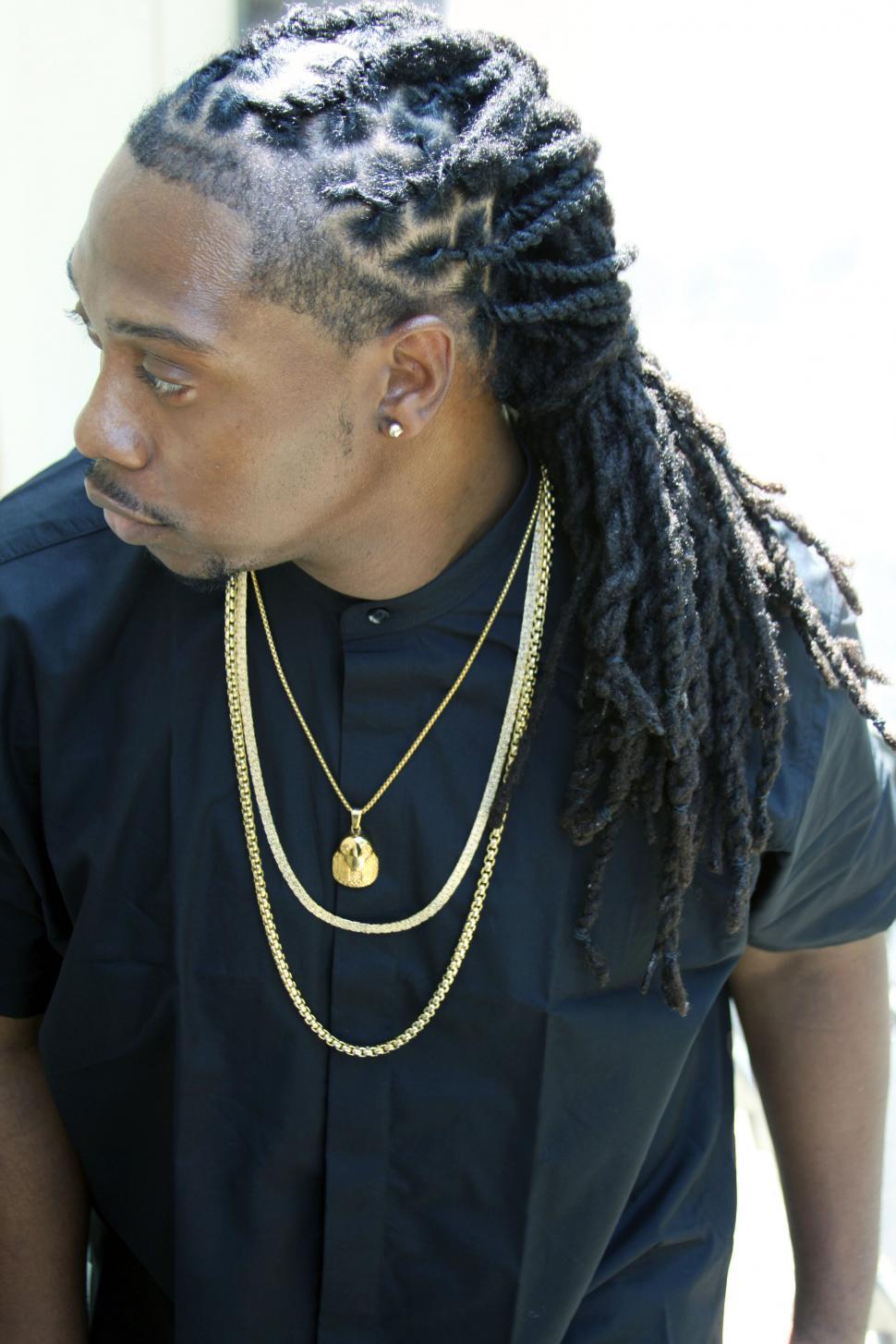 Free Image of Man with braided hairstyle showcasing gold chain 