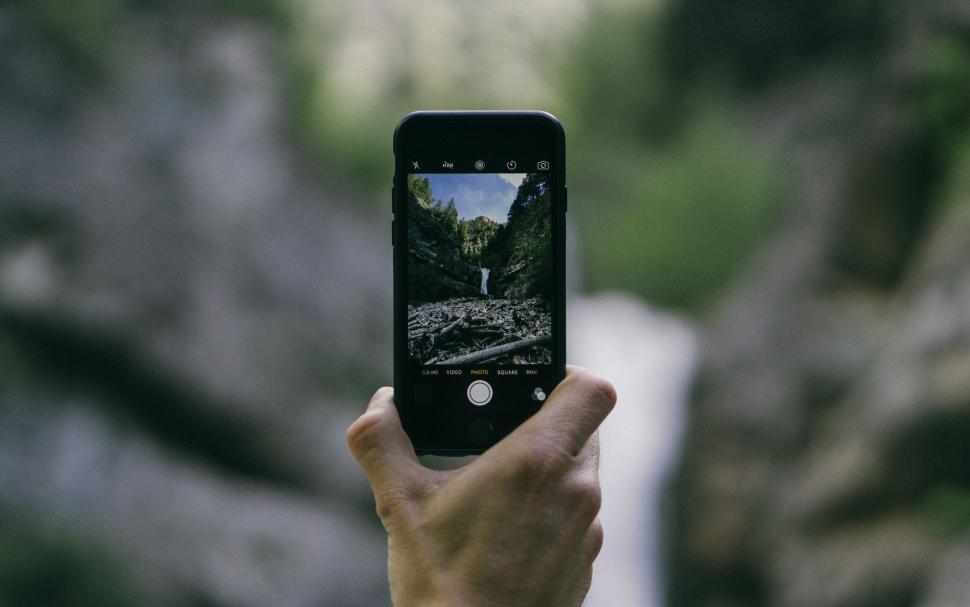 Free Image of Smartphone capturing a waterfall in nature 