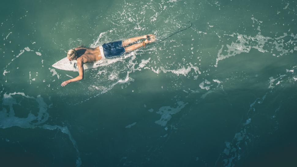 Free Image of Aerial view of a man paddleboarding in sea 
