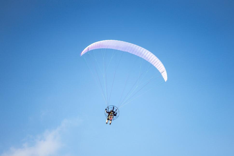 Free Image of Paraglider soaring in blue sky 