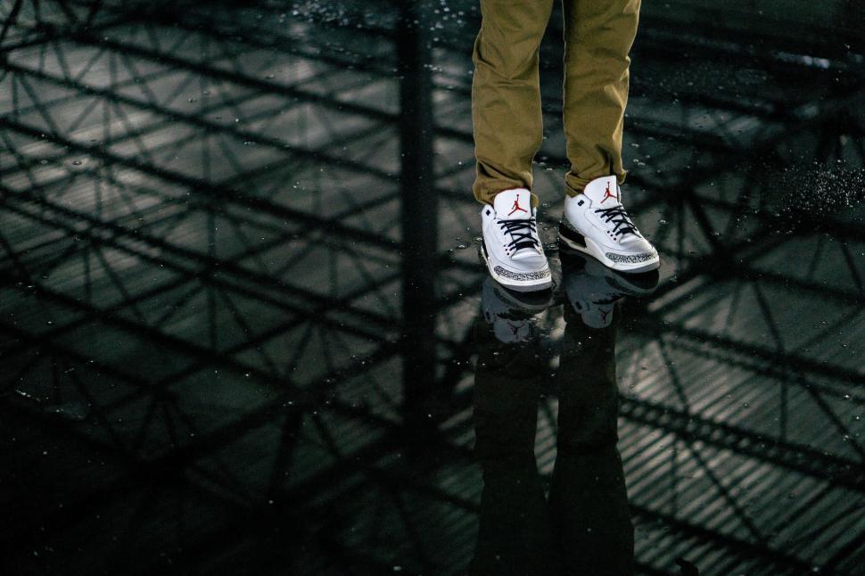 Free Image of Urban sneakers on reflective rainy surface 