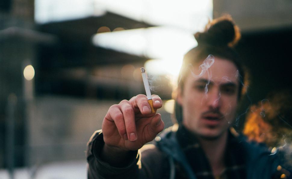 Free Image of Man holding cigarette in focus 