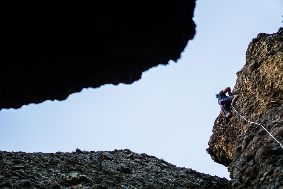 Free Image of Rock climber ascending a steep cliff 
