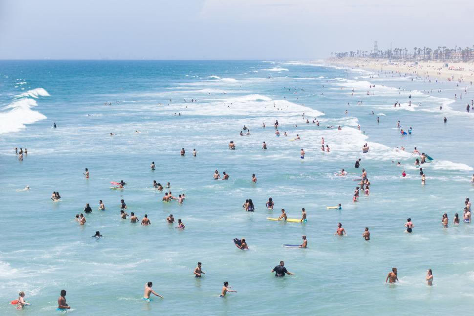 Free Image of Crowded beach scene with surfers and swimmers 
