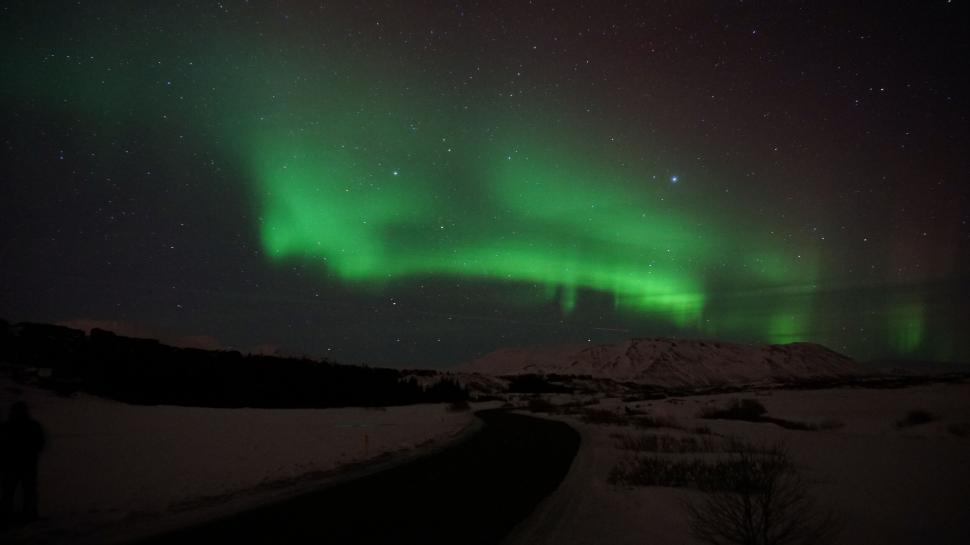 Free Image of Northern lights dancing over snowy landscape 