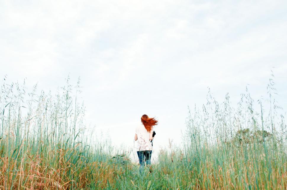 Free Image of Woman with flying red hair in open field 