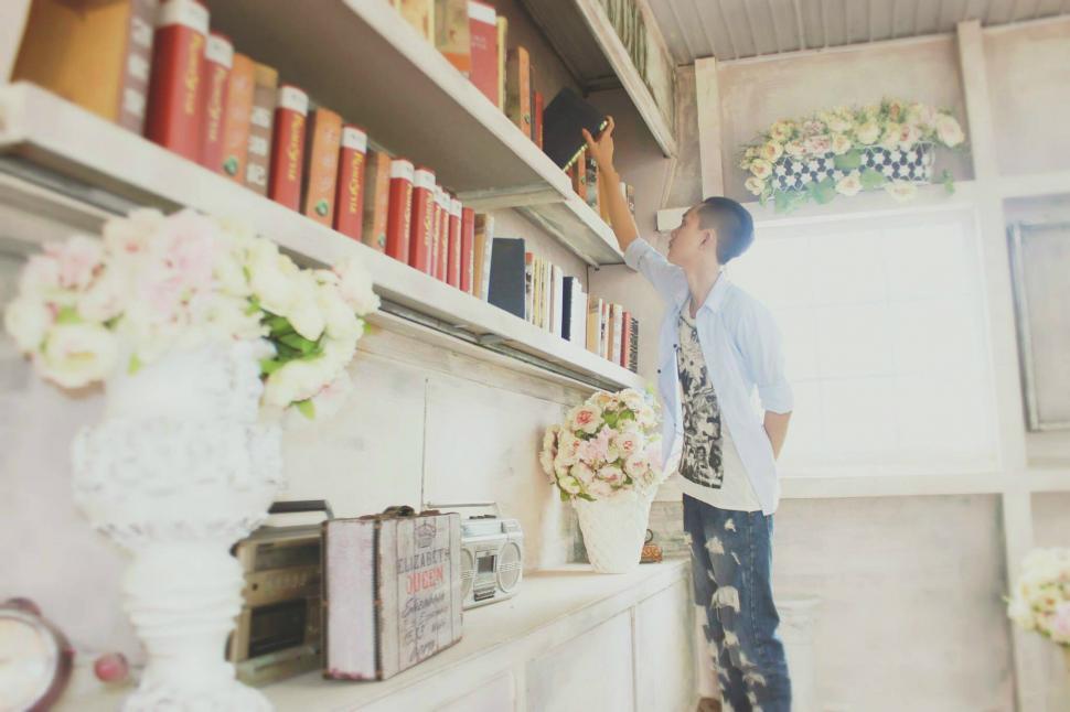Free Image of Person reaching for book in elegant room 