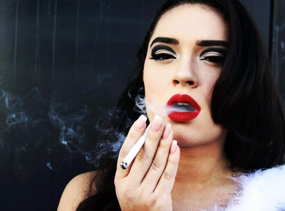 Free Image of Woman smoking with dramatic makeup 