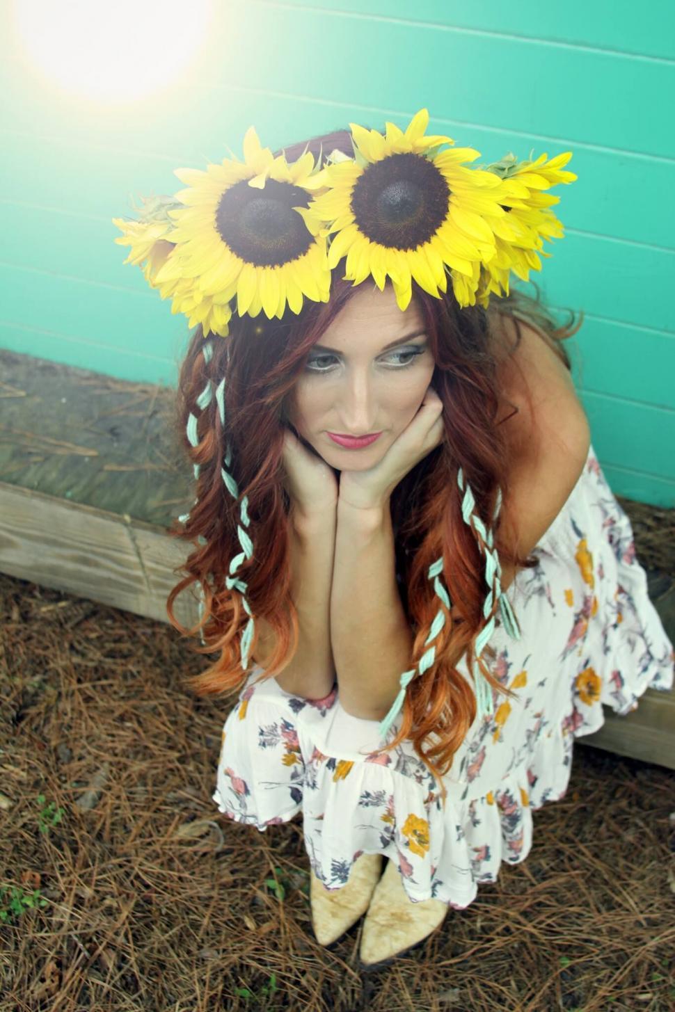 Free Image of Woman with sunflower headband crouching 