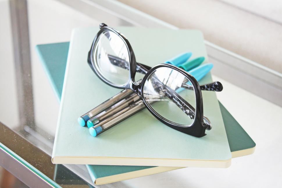 Free Image of Glasses and Pens on Top of Notebooks 