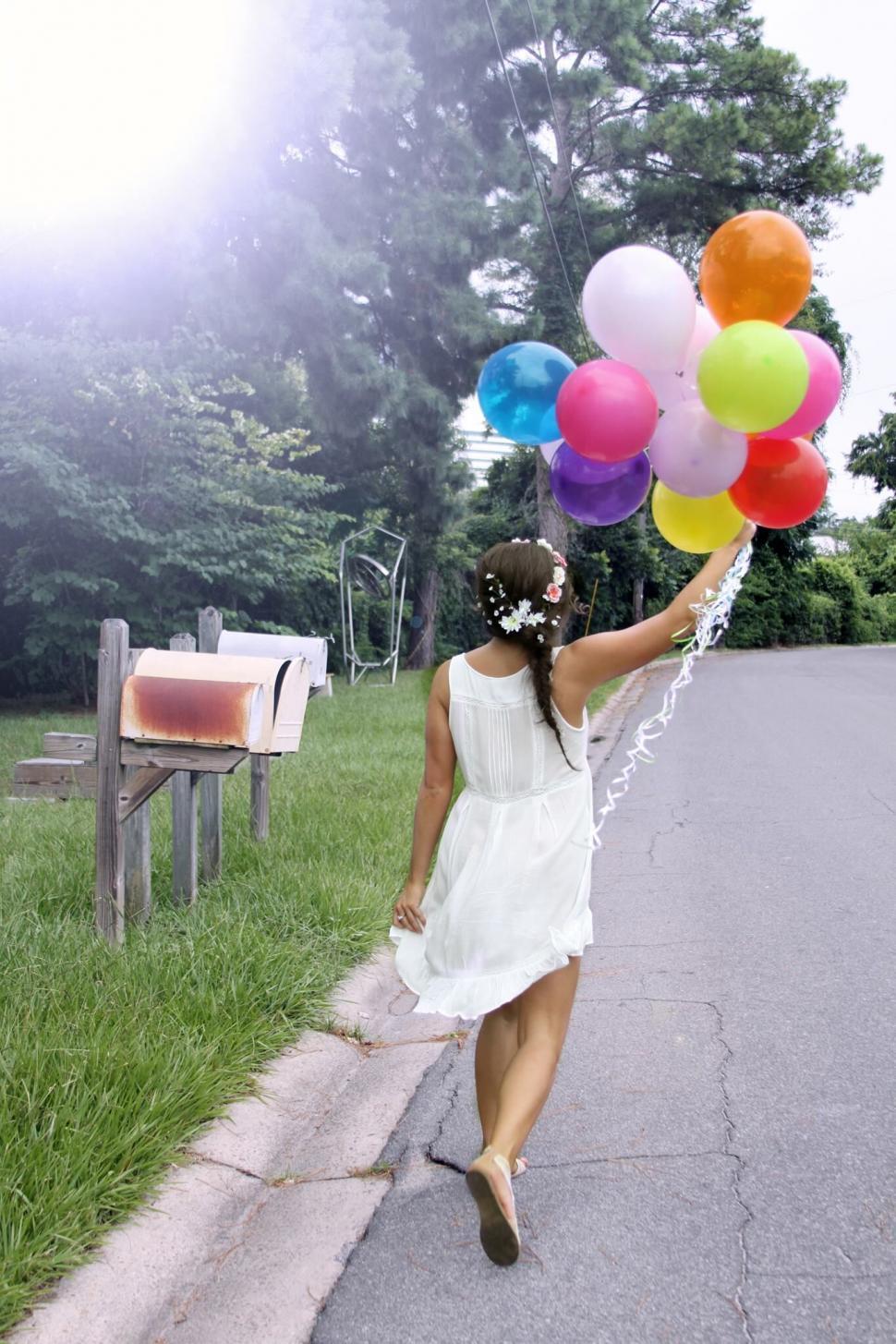 Free Image of Girl with balloons walking in a park 