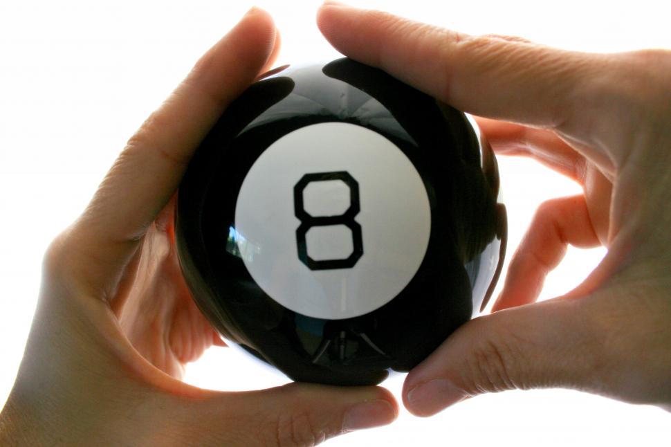Free Image of Hands holding a crystal ball with number 8 