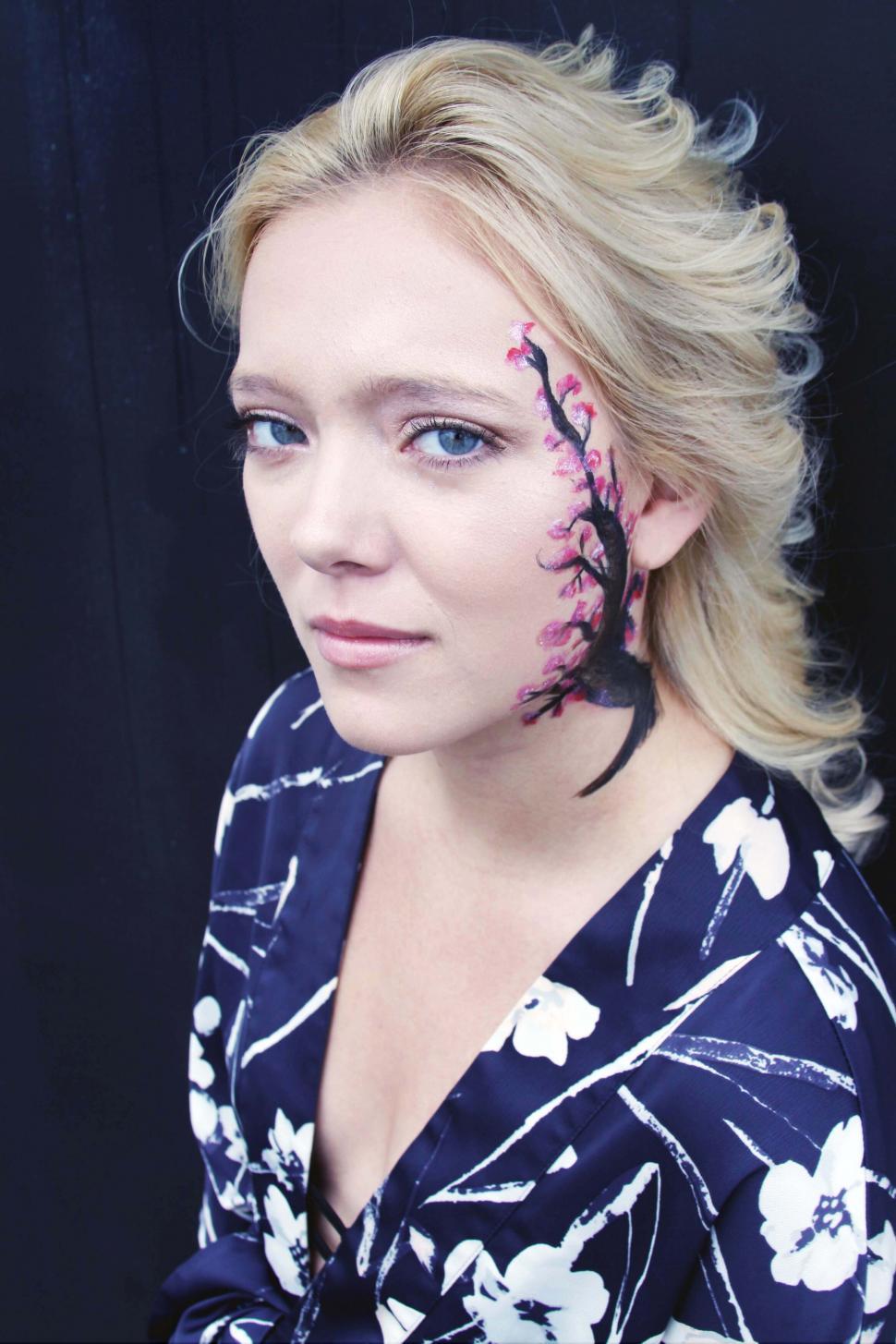 Free Image of Woman with floral face art looking serene 