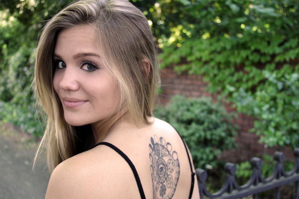 Free Image of Woman smiling with tattoo on shoulder 