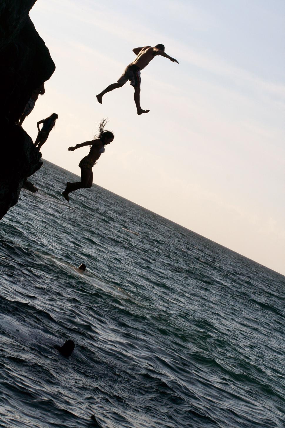Free Image of Youth jumping off a cliff into the sea 