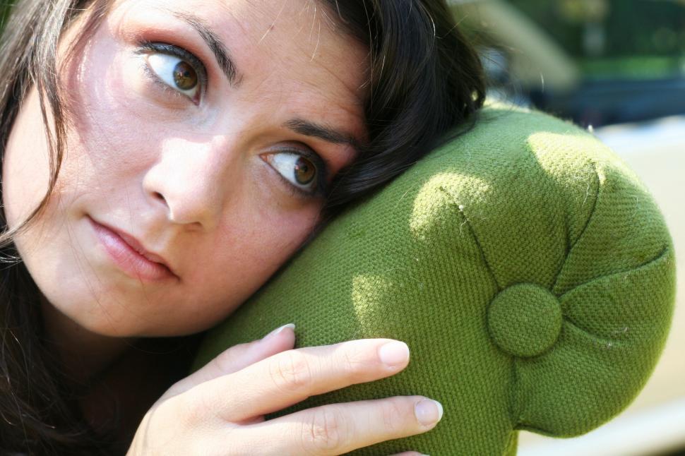 Free Image of Stuffed green toy resting on a shoulder 