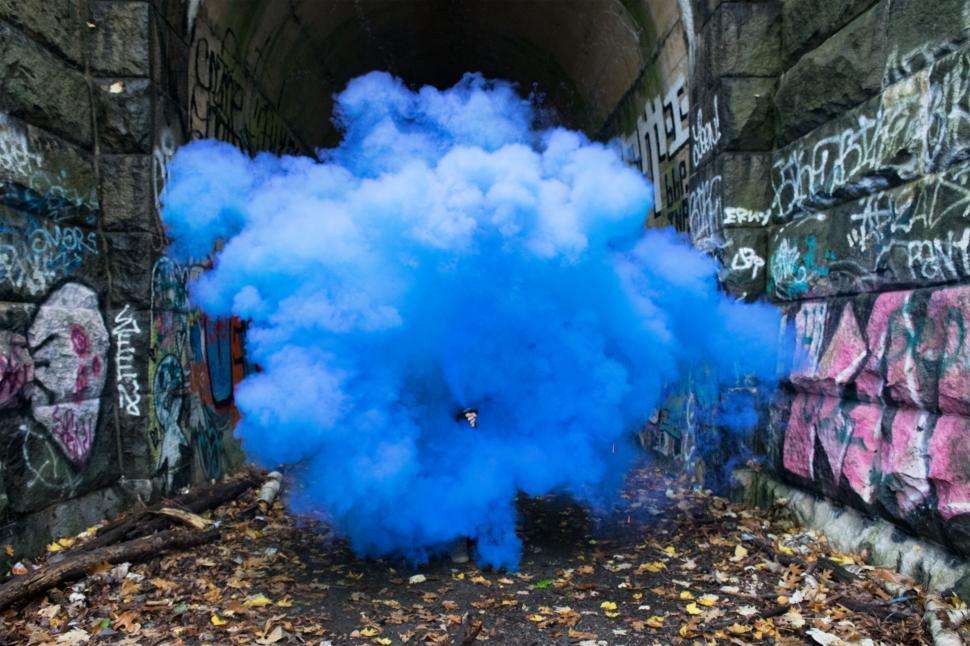 Free Image of Colorful smoke in a graffiti-covered tunnel 