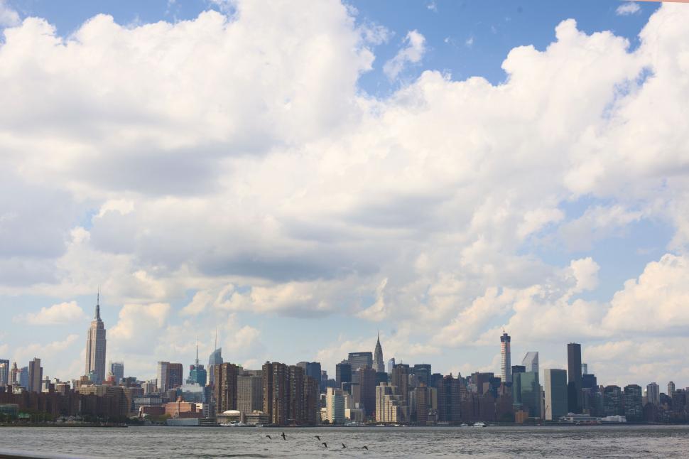 Free Image of Manhattan skyline with fluffy clouds 