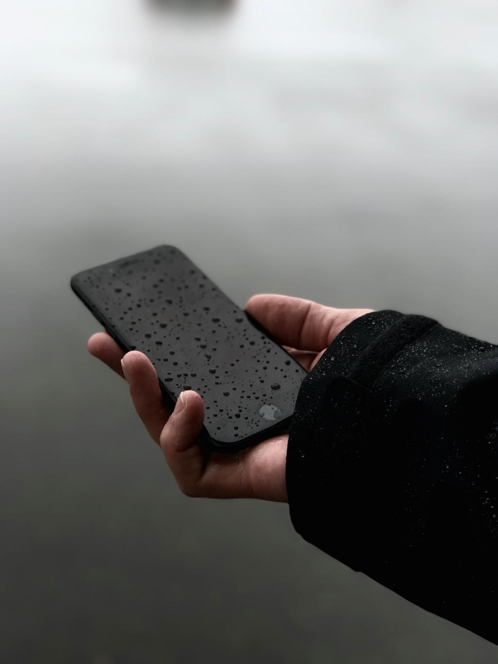 Free Image of Hand holding a wet smartphone 