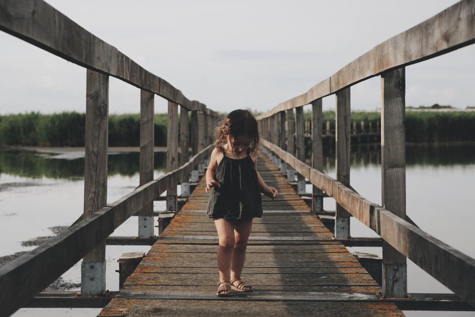 Free Image of Girl walking on a wooden bridge 