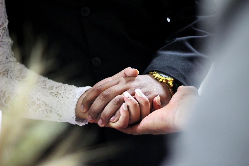 Free Image of Newlyweds holding hands at wedding 